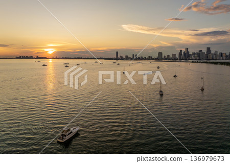 Florida travel destination. Recreational yachts and fishing boats on anchor in Biscayne Bay. Evening urban skyline with high-rises in downtown 136979673