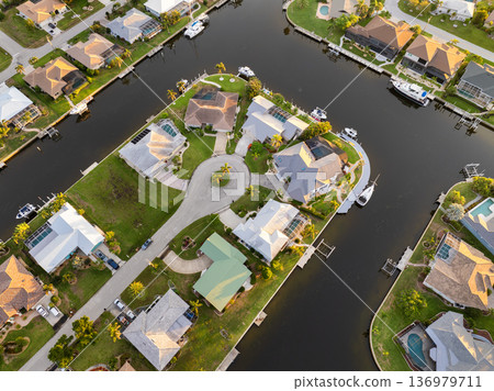 Punta Gorda, Florida waterfront at sunset with expensive mansions, palm trees and golden light over premium suburban homes. Punta Gorda, Florida waterfront at sunset with expensive mansions, palm trees and golden light over premium suburban homes. 136979711