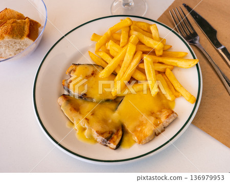 Cooked swordfish in hollandaise sauce with french fries close up 136979953