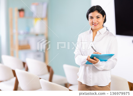Woman with paper folder in lecture hall 136979975