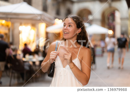 young woman walks through the evening streets of Barcelona 136979988