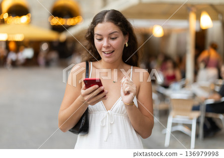 Young woman with phone walking around Barcelona Young woman with phone walking around Barcelona 136979998