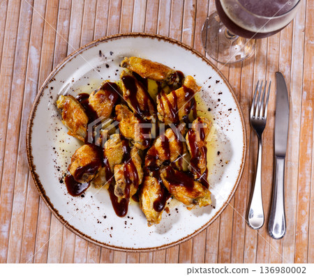 Grilled chicken wings with sauce bbq. Traditional spanish dish alitas en salsa BBQ Grilled chicken wings with sauce bbq. Traditional spanish dish alitas en salsa BBQ 136980002