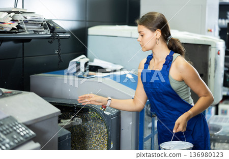 Hardware store employee combining just the right tints of paint in an electronically guided modern mixing machine 136980123