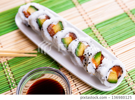 Japanese Uramaki and California rolls served in a plate with soya sauce Japanese Uramaki and California rolls served in a plate with soya sauce 136980125
