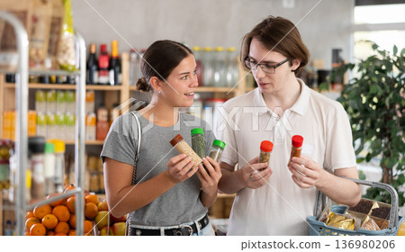 European youth girl and guy choose and buy spices and seasonings herbs in store European youth girl and guy choose and buy spices and seasonings herbs in store 136980206