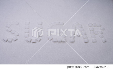 Sugar cubes arranged to spell sugar on a white surface creating a simple but striking visual statement about sweetness Sugar cubes arranged to spell sugar on a white surface creating a simple but striking visual statement about sweetness 136980320