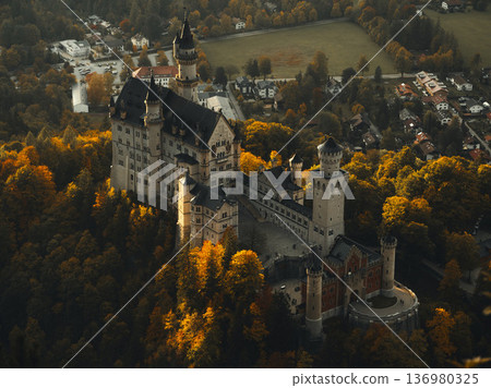 Bavarian castle stands among autumn trees as golden leaves cover the landscape in the late afternoon light Bavarian castle stands among autumn trees as golden leaves cover the landscape in the late afternoon light 136980325