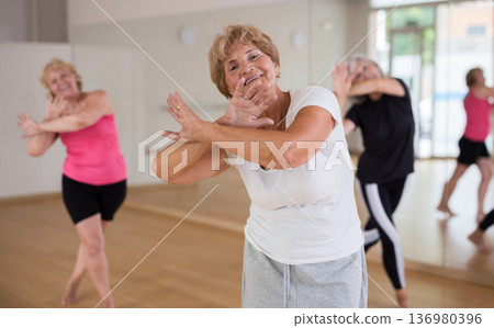 Energetic elderly woman practicing vigorous dance movements Energetic elderly woman practicing vigorous dance movements 136980396