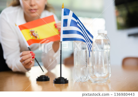 Young female secretary preparing room for international negotiations between greece and spain Young female secretary preparing room for international negotiations between greece and spain 136980443