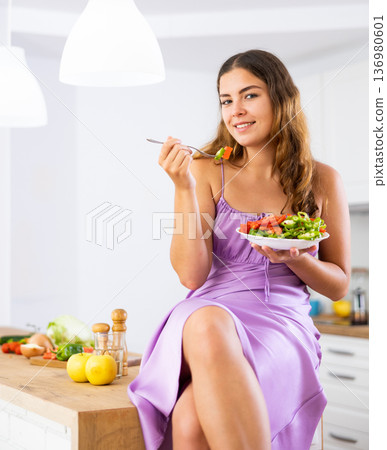 Portrait of woman eating salad at home Portrait of woman eating salad at home 136980601