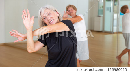 Active mature woman learning dynamic dances in choreography class Active mature woman learning dynamic dances in choreography class 136980613