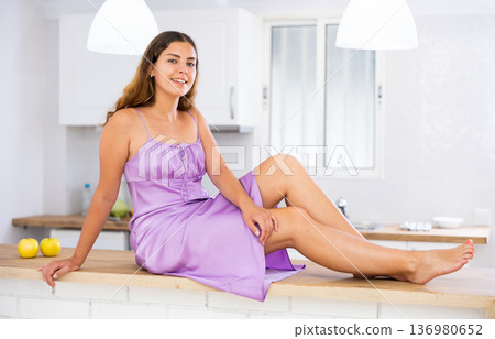 Portrait of attractive female who is posing in kitchen 136980652