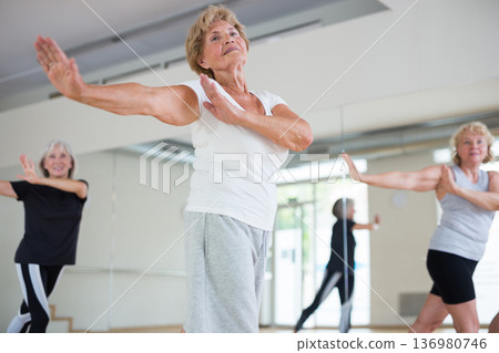 Senior women in sportswear dancing inside gym 136980746