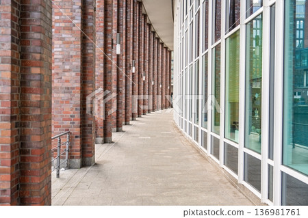 Architectural Contrast in Hamburg Brick Pillars Meet Modern Glass Facade Along The Walkway 136981761