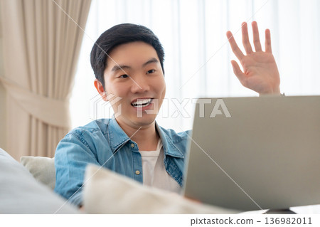 Young Asian man relaxing on comfortable couch Young Asian man relaxing on comfortable couch 136982011