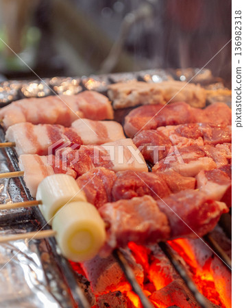 Close-up of yakiton being grilled slowly on a grill. Vertical shot of the texture of the pork heated by the charcoal fire and the cooking process Close-up of yakiton being grilled slowly on a grill. Vertical shot of the texture of the pork heated by the charcoal fire and the cooking process 136982318