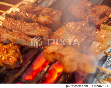 A standard menu item at izakayas, grilled yakiton is a savory pork skewer dish that symbolizes the lively nightlife of Japan. 136982321