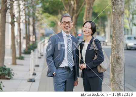 一對身著西裝、面帶微笑的夫婦 一對身著西裝、面帶微笑的夫婦 136982339