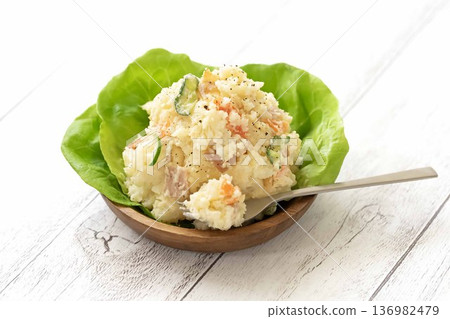Potato salad served on a wooden plate with lettuce Potato salad served on a wooden plate with lettuce 136982479