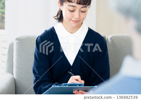 A female care manager talking to a client A female care manager talking to a client 136982539
