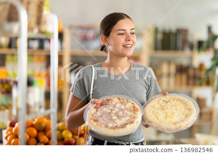 European youth girl choose and buy pizza with filling in store 136982546