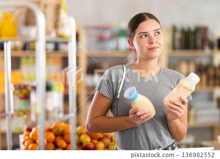 Young woman choosing mayonnaise in grocery store 136982552