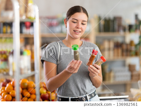 Woman chooses spices and seasonings Woman chooses spices and seasonings 136982561