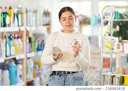 Woman holding cans in her hands in a store 136982616