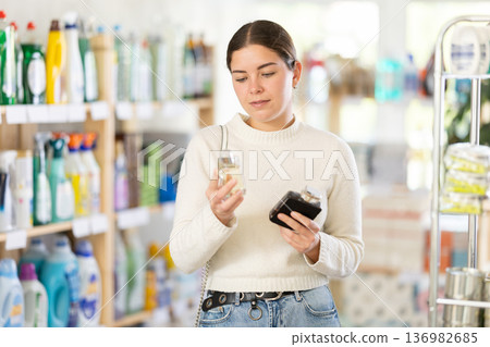 Young woman client sniffs fragrance of perfume, chooses scent spray with pleasant smell 136982685