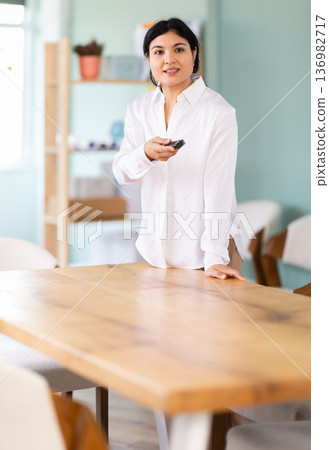 In lecture hall, woman with remote control 136982717
