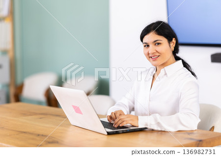 Female works on laptop in room Female works on laptop in room 136982731