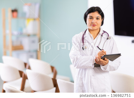 Woman doctor with tablet in lecture hall Woman doctor with tablet in lecture hall 136982751