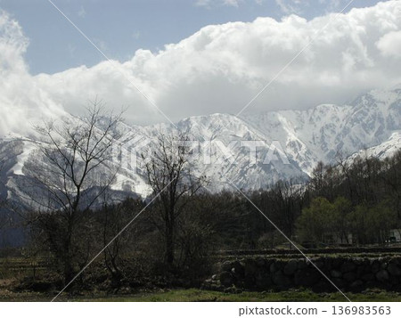 北十勝山脈在雲霧繚繞和春雪未消的情況下綿延展開。 北十勝山脈在雲霧繚繞和春雪未消的情況下綿延展開。 136983563