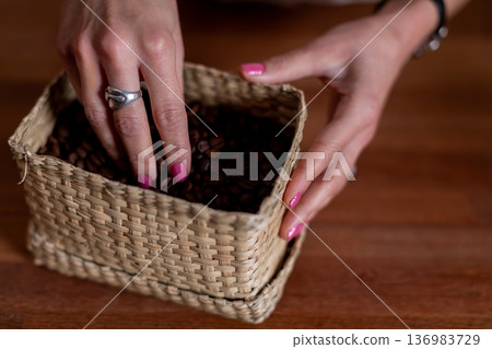 Sparkling hands meticulously examine freshly roasted aromatic coffee beans, Fine jewelry on hands enhances careful inspection of aromatic coffee beans under warm lighting Sparkling hands meticulously examine freshly roasted aromatic coffee beans, Fine jewelry on hands enhances careful inspection of aromatic coffee beans under warm lighting 136983729