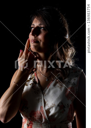 Silent grateful pose, Woman quietly expressing deep appreciation, Serene woman showing thankfulness in soft lighting, Peaceful moment of gratitude captured in gentle glow 136983754