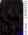 Sparkling tips and polished surface enhance detailed hairstyle, Subtle shimmer on dark hair creates tactile glossy look highlighting curl ends and surface refinement 136983762