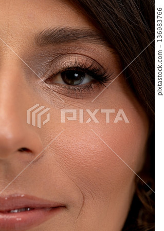 Stunning lady displaying luminous eye cosmetic details up close, Elegant female featuring captivating eyes highlighted with sparkling makeup in detailed closeup 136983766