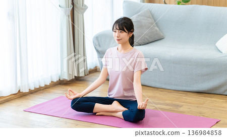 一位女士正在家中的客廳做瑜伽 136984858