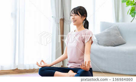 Woman doing yoga in her living room at home Woman doing yoga in her living room at home 136984860