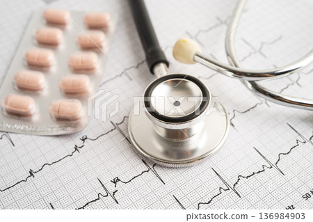 Stethoscope on electrocardiogram ECG with capsule drug, heart wave, heart attack, cardiogram report. 136984903