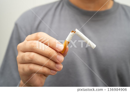Quit smoking, Asian teenage man breaking destroy cigarette in hand. Quit smoking, Asian teenage man breaking destroy cigarette in hand. 136984906