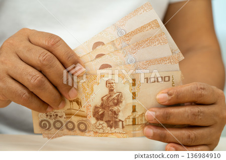 Asian woman holding Thai banknotes money, economy finance exchange trade investment. 136984910