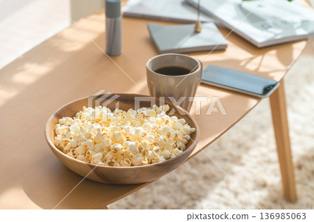 Popcorn, snacks, and coffee on the living room table Popcorn, snacks, and coffee on the living room table 136985063