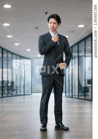 一位表情嚴肅的男商人站在那裡。 一位表情嚴肅的男商人站在那裡。 136985166