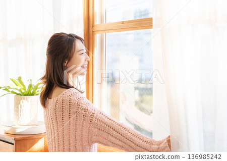 女人打開窗簾 136985242