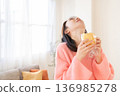 A young woman eating bread 136985278