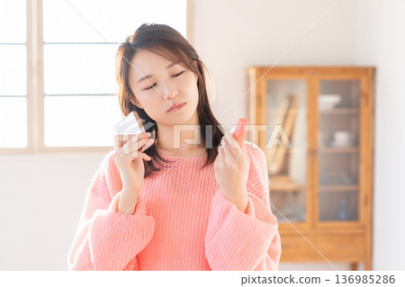 Young woman putting on makeup thinking 136985286