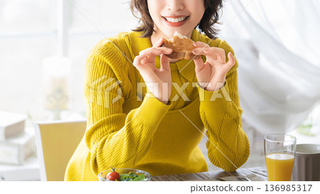 女人正在吃早餐麵包 女人正在吃早餐麵包 136985317