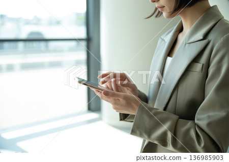 操作智慧型手機的女性生成人工智慧 136985903